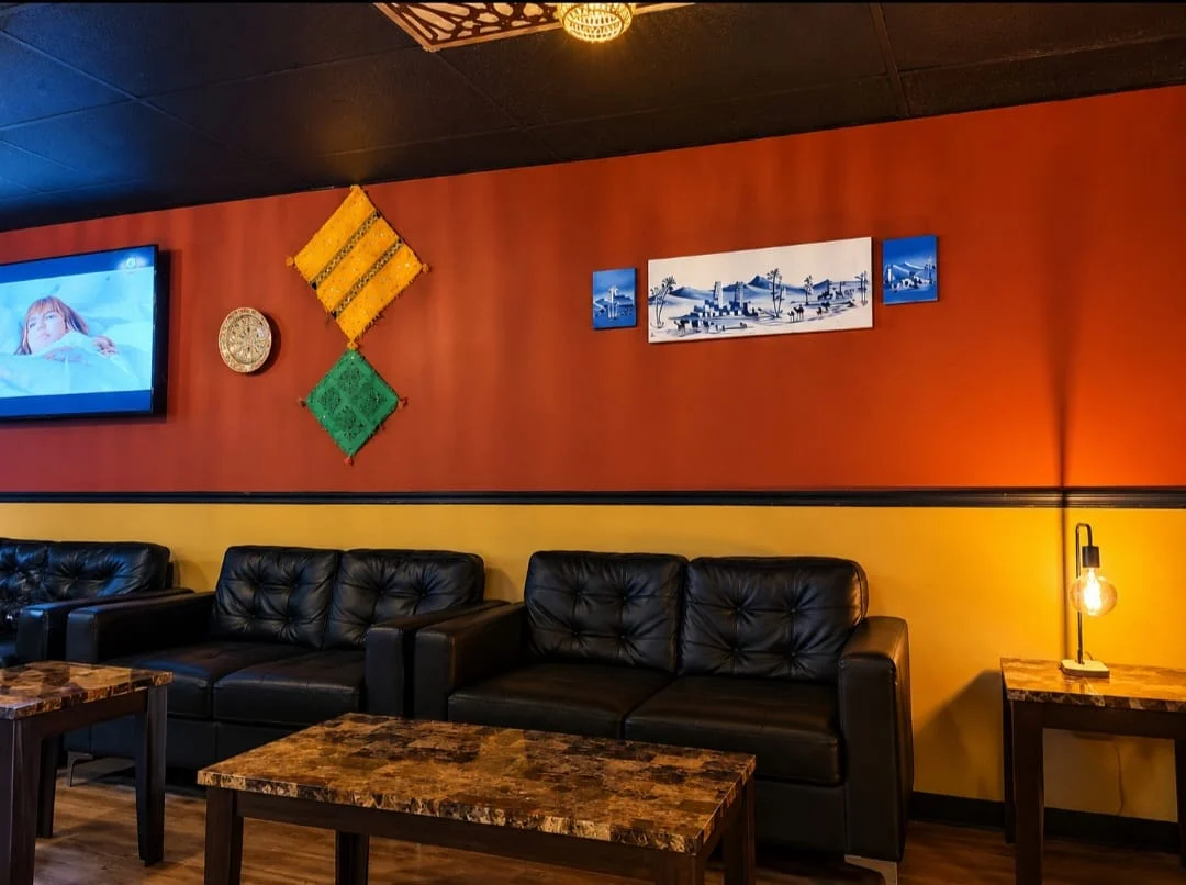 Black leather sofas beside the terracotta wall