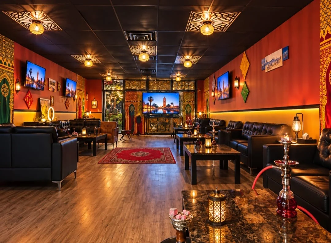 Moroccan-inspired lounge with warm lighting and black leather seating